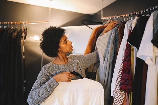 Woman hanging clothes on clothes rack